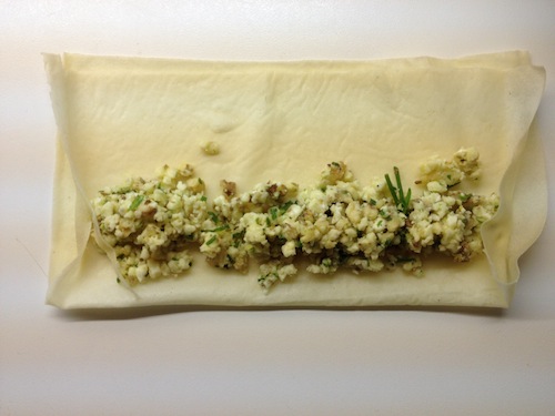 Vouw de blaadjes dubbel en leg er op de onderste rand een rol van de camembertmassa op.