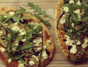 Naanbrood belegd met heerlijke gegrilde aubergine, zoute feta en olijfjes en pittige rucola. Een topper!