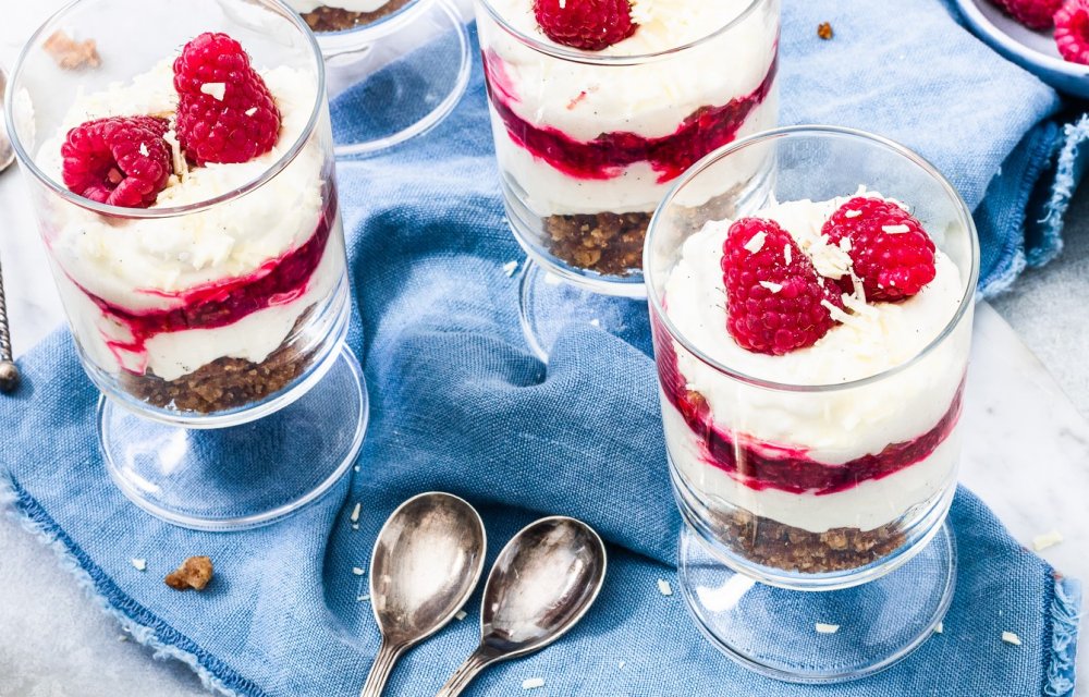 CheesecaCheesecake met frambozen in een glaasjeke met frambozen in een glaasje