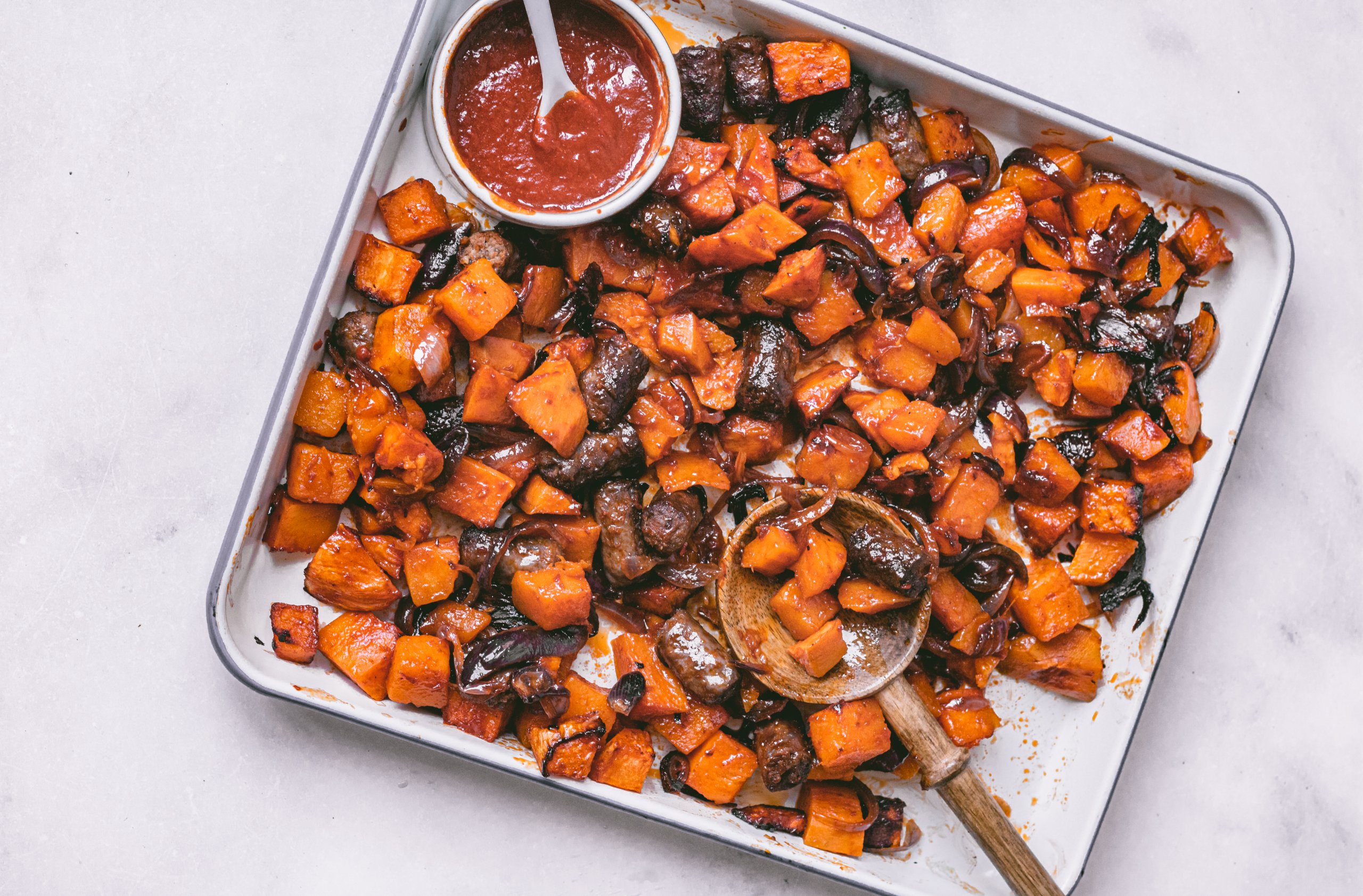 Traybake met sticky spicy worst en zoete aardappel